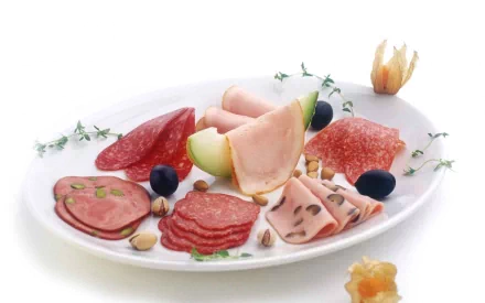 HD PC desktop wallpaper featuring a delicious assortment of sliced meats and olives artfully arranged on a white plate with herbs and garnish.