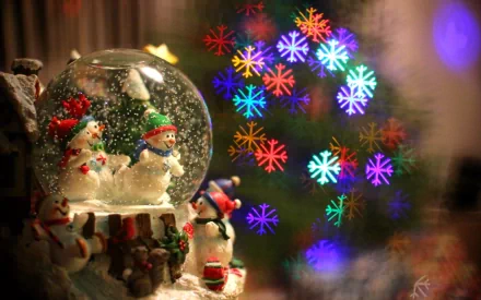 A charming snow globe featuring cheerful snowmen and a festive holiday scene, complemented by a beautifully lit Christmas tree in the background, creating a warm, seasonal atmosphere.