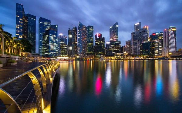 HD desktop wallpaper featuring the illuminated Singapore skyline at night, showcasing modern man-made skyscrapers reflected on calm waterfront.