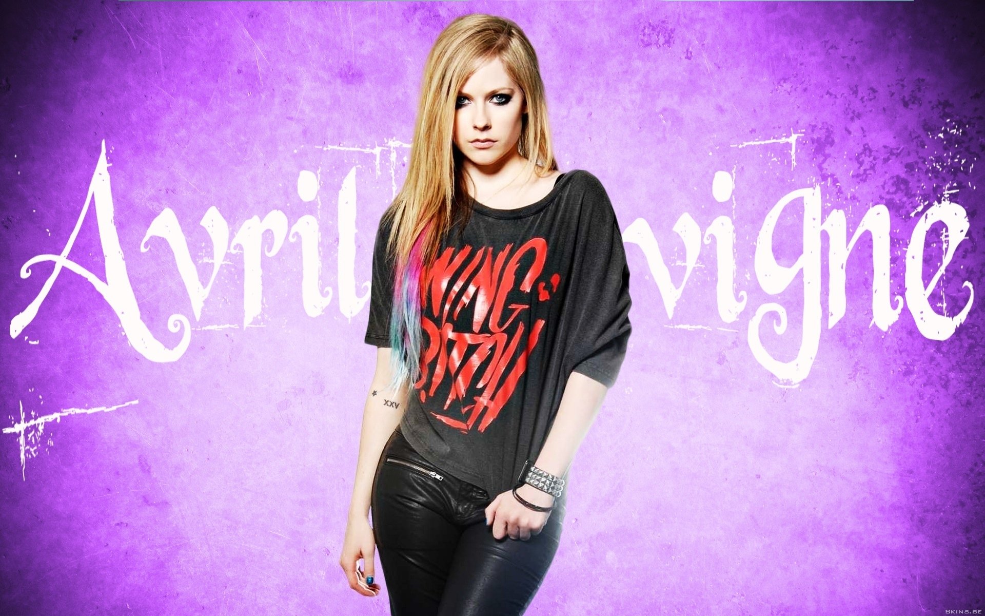 HD PC desktop wallpaper featuring Avril Lavigne against a purple grunge background with her name in stylized white text, highlighting music and pop culture.