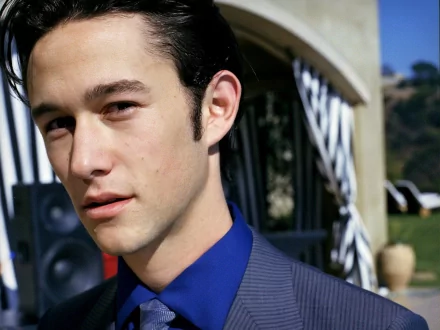 Joseph Gordon-Levitt poses confidently in a stylish suit against a vibrant outdoor background, captured in high-definition for a striking desktop wallpaper.