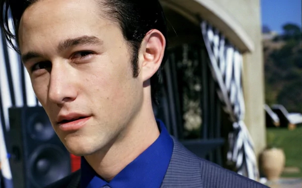 Joseph Gordon-Levitt poses confidently in a stylish suit against a vibrant outdoor background, captured in high-definition for a striking desktop wallpaper.
