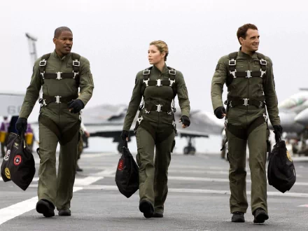 HD PC desktop wallpaper from the movie Stealth, featuring three pilots walking confidently on an aircraft carrier deck in flight suits.