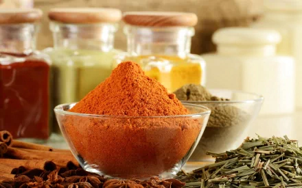 A vibrant HD PC desktop wallpaper featuring various herbs and spices in glass bowls and jars, showcasing rich colors and textures of food seasonings.