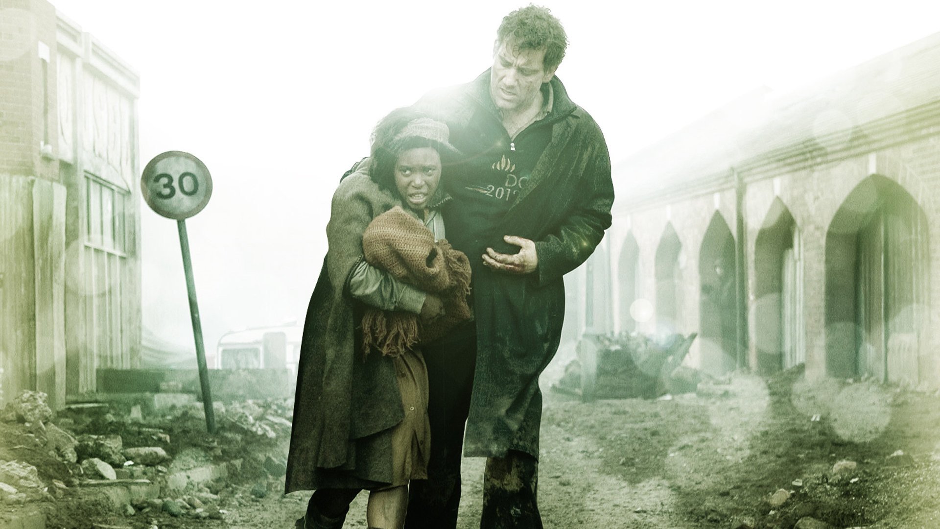 HD wallpaper of a scene from Children Of Men featuring Clive Owen in a protective stance with a child in a dystopian setting.