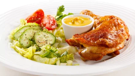 HD desktop wallpaper featuring a plated meal with roasted chicken, fresh salad of cucumbers and tomatoes, and a side of dipping sauce on a white plate.