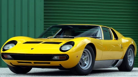 HD desktop wallpaper featuring a bright yellow Lamborghini Miura parked in front of a green industrial shutter, showcasing its classic sports car design.