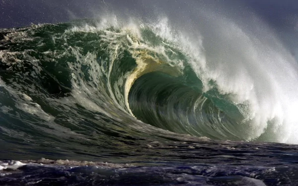 HD desktop wallpaper featuring a powerful ocean wave curling with frothy spray under a moody sky, capturing the raw beauty of nature's ocean waves.