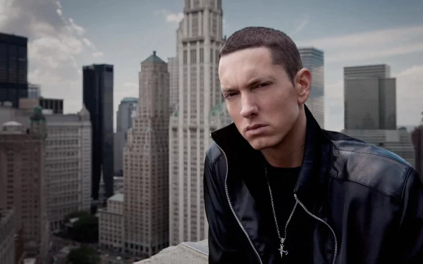 HD desktop wallpaper featuring Eminem in front of a cityscape with towering buildings and a cloudy sky. The image has a musical theme.