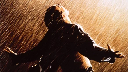 HD desktop wallpaper of a scene from The Shawshank Redemption with a person in the rain, arms outstretched, embodying freedom.