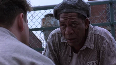 Morgan Freeman in a scene from The Shawshank Redemption, engaging in a heartfelt conversation, captured in this HD desktop wallpaper.