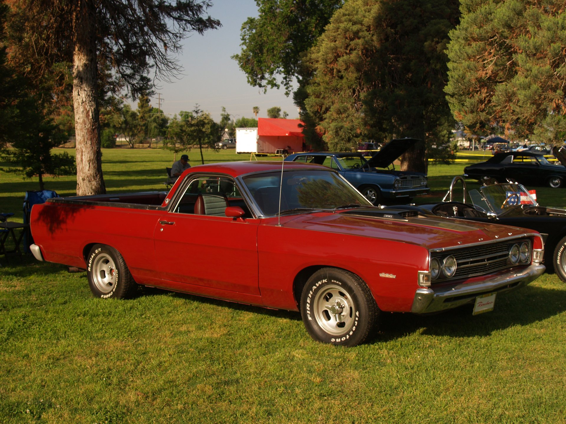 HD PC desktop wallpaper featuring a classic red Ford Ranchero parked on grass with trees and a red barn in the background.