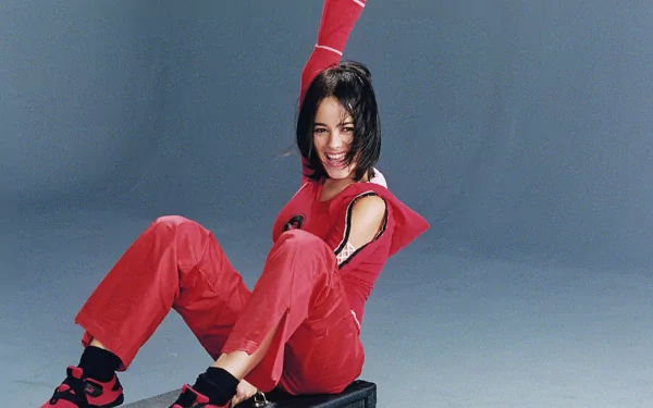 HD PC desktop wallpaper featuring singer Alizée in a vibrant red outfit, smiling and posed against a simple gray background with a musical theme.
