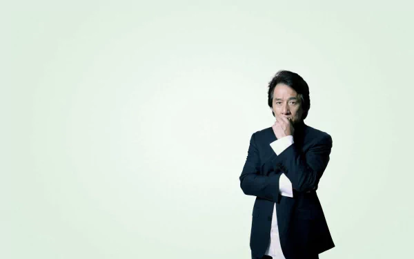HD wallpaper of celebrity Jackie Chan in a thoughtful pose against a light green background.