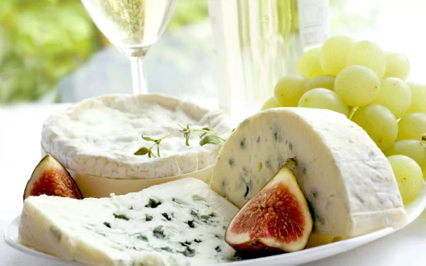 HD desktop wallpaper featuring a delicious cheese platter with blue cheese, brie, fresh figs, and green grapes, highlighting a gourmet food presentation.