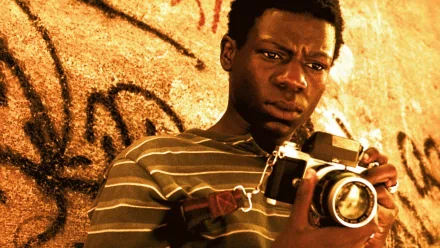 HD desktop wallpaper from City of God featuring a person holding a camera against a graffiti-covered wall.