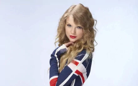 HD desktop wallpaper featuring Taylor Swift dressed in a blue, white, and red striped outfit, with curly blonde hair and red lipstick, set against a light background. Tags: music, Taylor Swift.