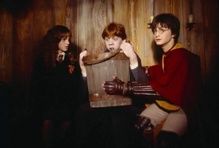 HD wallpaper featuring three young wizards from Harry Potter and the Chamber of Secrets analyzing a mysterious object.