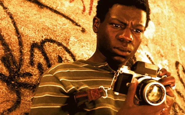 HD desktop wallpaper from City of God featuring a person holding a camera against a graffiti-covered wall.