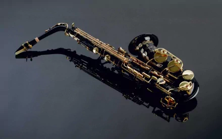 A sleek saxophone elegantly displayed on a reflective surface, showcasing its intricate keys and design, serves as a striking HD wallpaper and background for music enthusiasts.