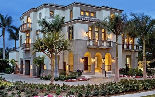 HD desktop wallpaper featuring a grand, illuminated multi-story house with palm trees, lush landscaping, and a twilight sky background.