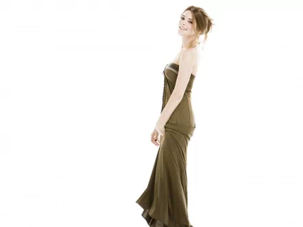 HD desktop wallpaper featuring celebrity Ashley Greene in a sleek, strapless brown gown against a bright, minimalist white background.