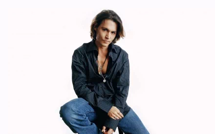 A high-definition desktop wallpaper featuring Johnny Depp, showcasing him in a stylish, relaxed pose, wearing a striped shirt and jeans against a minimalist background.