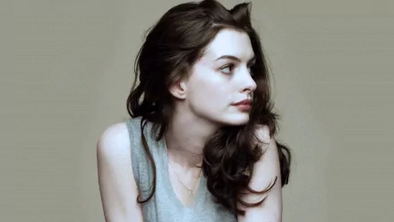 A captivating HD desktop wallpaper featuring Anne Hathaway, showcasing her profile with soft, flowing hair against a neutral background.