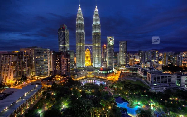 Nighttime view of Kuala Lumpur's skyline featuring the illuminated man-made Petronas Towers, captured in an HD desktop wallpaper and background.