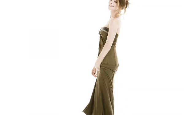 HD desktop wallpaper featuring celebrity Ashley Greene in a sleek, strapless brown gown against a bright, minimalist white background.