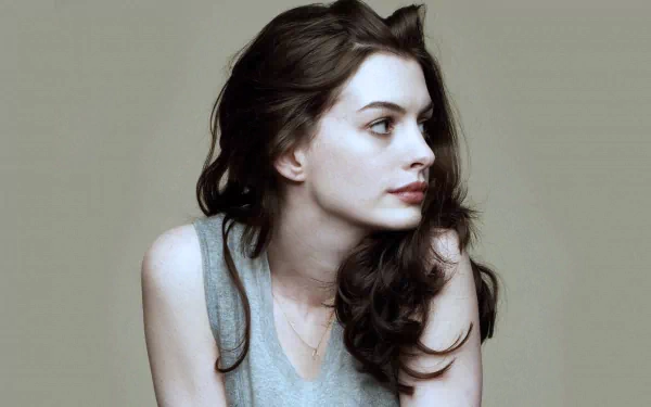 A captivating HD desktop wallpaper featuring Anne Hathaway, showcasing her profile with soft, flowing hair against a neutral background.