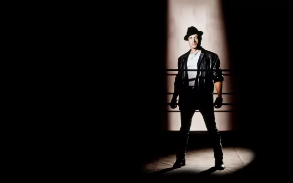 HD PC desktop wallpaper featuring Sylvester Stallone as Rocky Balboa from the movie Rocky V, standing in a dramatic spotlight with a dark background.