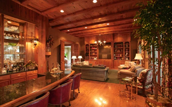 A cozy room with wooden beams and elegant furnishings, featuring a bar, plush seating, and a stylish decor, captured as a 4K Ultra HD PC desktop wallpaper.
