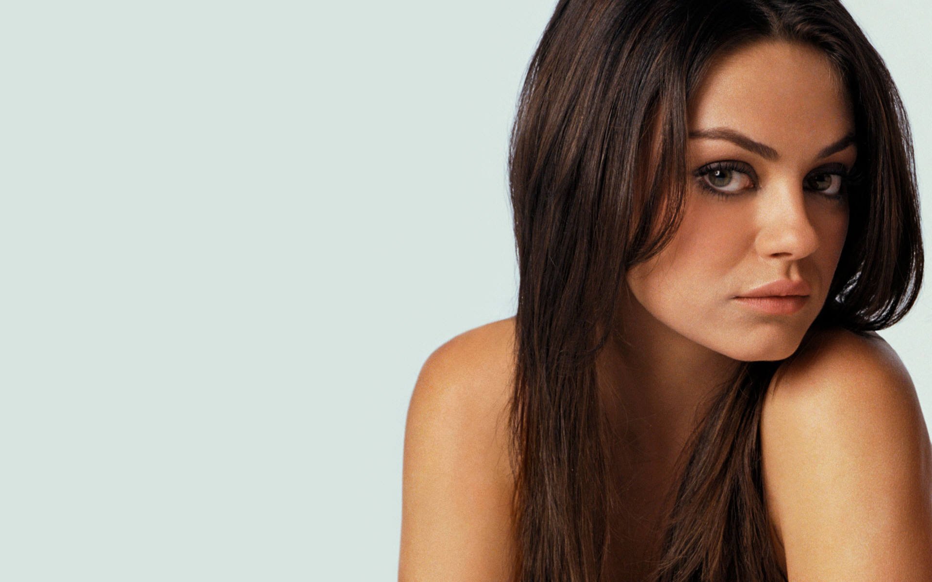 HD PC desktop wallpaper featuring a close-up portrait of celebrity Mila Kunis against a light background.
