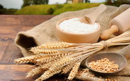 HD PC desktop wallpaper showcasing wheat stalks, a bowl of flour, and grains on a rustic wooden table, highlighting food and baking elements.