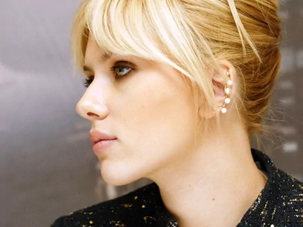 HD desktop wallpaper featuring celebrity Scarlett Johansson in a profile view, showcasing her elegant side profile and chic updo. The background is softly blurred.