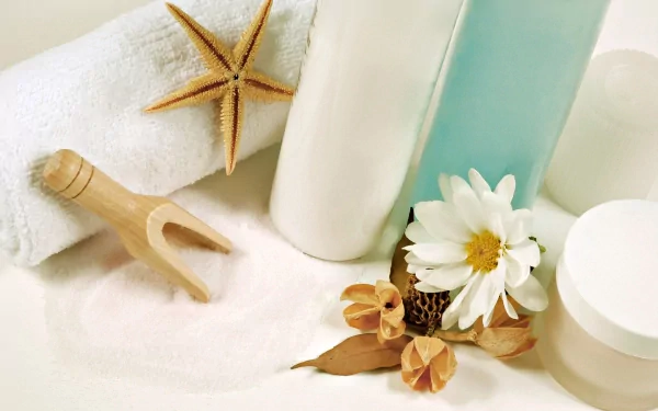 HD desktop wallpaper featuring a man-made spa setup with bottles, a towel, a starfish, and flowers arranged on a soft surface.