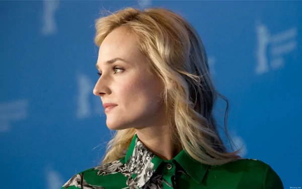 HD desktop wallpaper of celebrity Diane Kruger in a green blouse, captured in profile against a soft blue background.