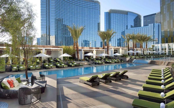 4K Ultra HD desktop wallpaper of a man-made resort with a large pool, palm trees, lounge chairs, and modern skyscrapers in the background.