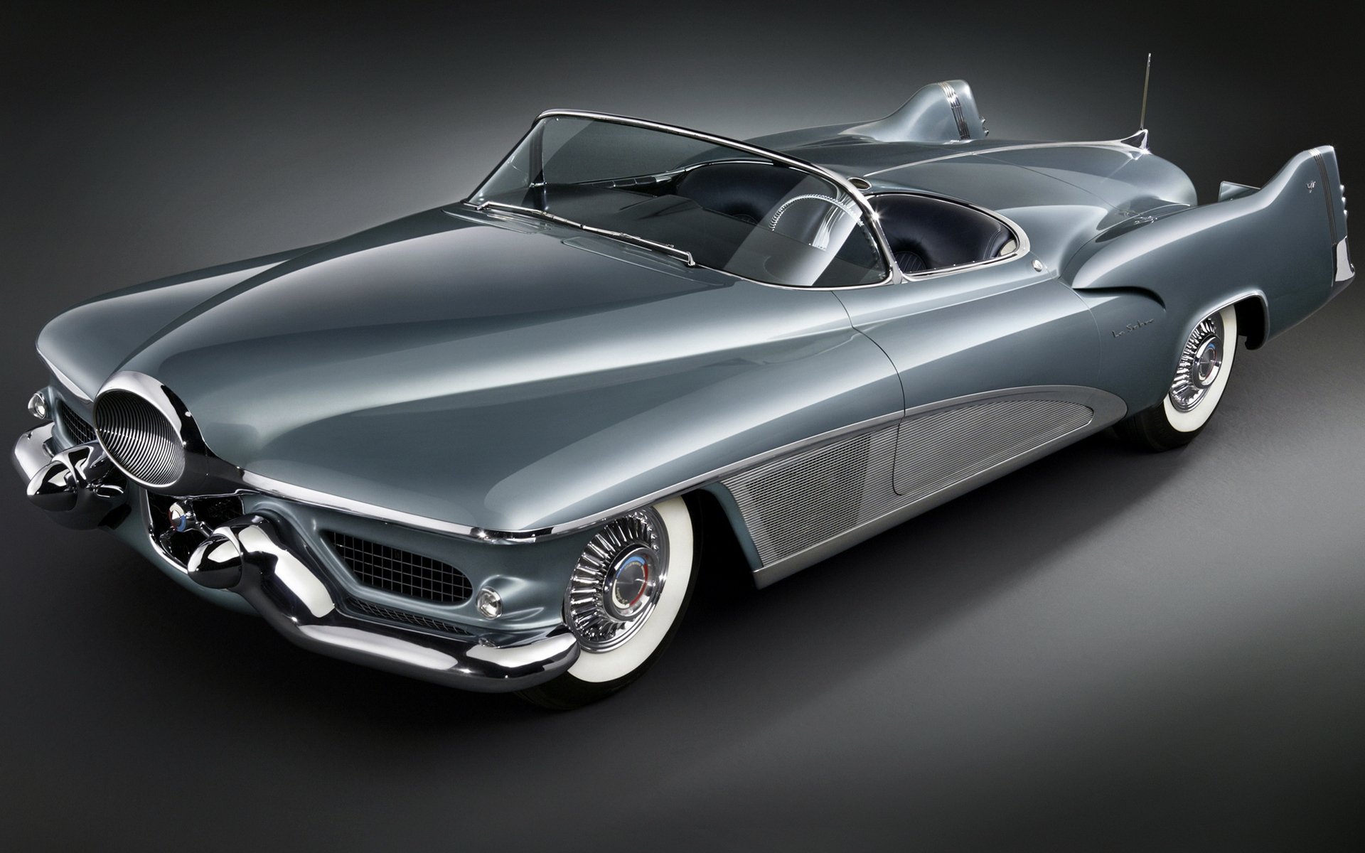 A sleek 1951 Buick LeSabre convertible, showcasing its classic design and chrome details, set against a dark background, making it a striking HD desktop wallpaper and background.