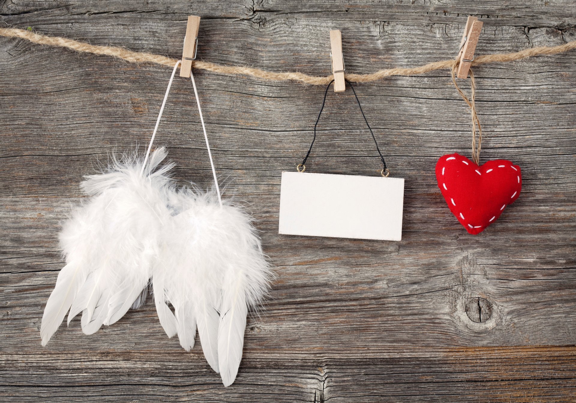4K Ultra HD Valentine's Day desktop wallpaper featuring white angel wings, a blank hanging sign, and a red stitched heart hanging on a rustic wooden background.