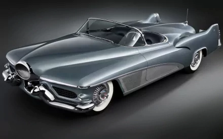 A sleek 1951 Buick LeSabre convertible, showcasing its classic design and chrome details, set against a dark background, making it a striking HD desktop wallpaper and background.