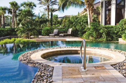 HD PC desktop wallpaper showing a man-made tropical pool with a circular spa, pebble edging, palm trees and lounge chairs in a lush resort setting.