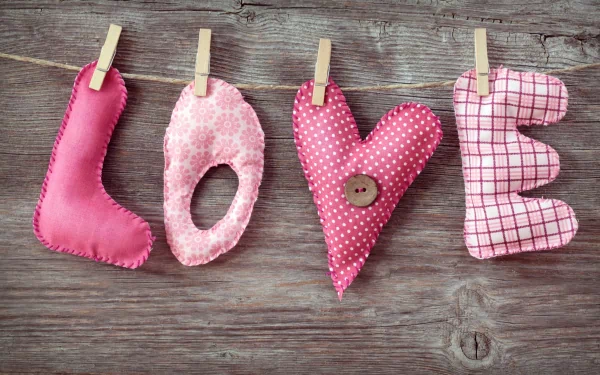 HD PC desktop wallpaper featuring handmade fabric letters spelling LOVE clipped on a rustic wooden background, celebrating Valentine's Day and the holiday spirit.
