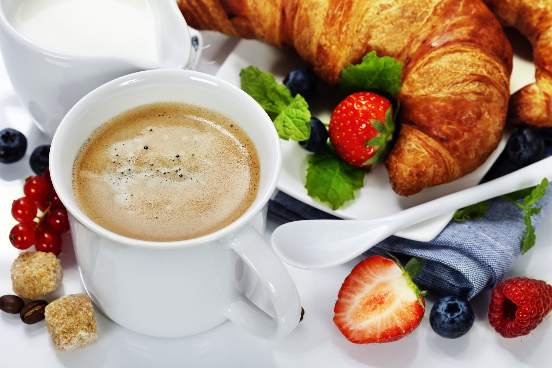 4K Ultra HD PC desktop wallpaper of a coffee cup with frothy cappuccino, fresh croissants, strawberries, blueberries, and mint leaves arranged on a white plate.