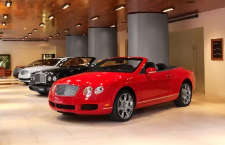 HD PC desktop wallpaper featuring a sleek red Aston Martin convertible displayed indoors alongside classic vehicles.