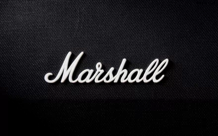 Music-themed HD PC desktop wallpaper: white Marshall script logo centered on a black textured speaker-grille background.