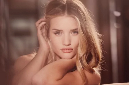 A stunning HD wallpaper featuring Rosie Huntington-Whiteley, showcasing her captivating beauty and expressive gaze, set against a soft, blurred background.