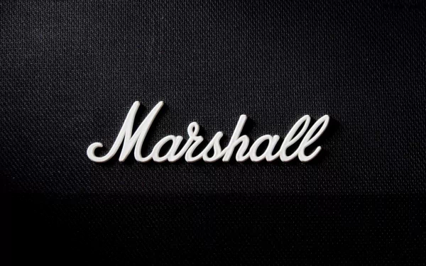 Music-themed HD PC desktop wallpaper: white Marshall script logo centered on a black textured speaker-grille background.