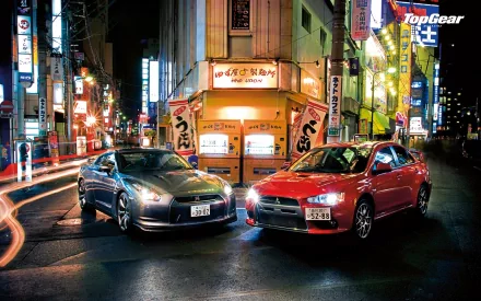 HD desktop wallpaper of two cars on a vibrant city street at night with Top Gear logo.